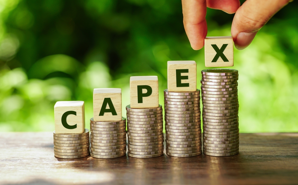 Hand,picks,up,capex,letter,blocks,and,stack,coins,,business